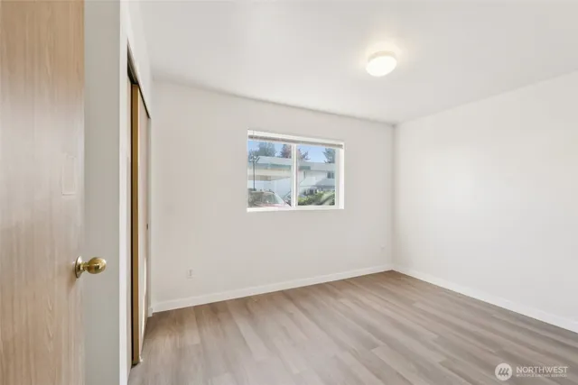 an empty room with wooden floor and window
