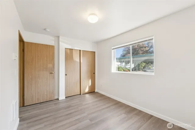 an empty room with wooden floor and window