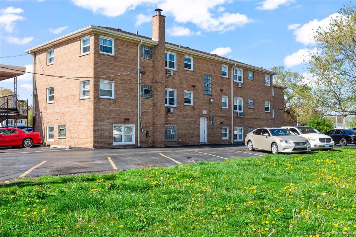 7110 West 107th Street, Unit 16 Worth, IL 60482 - Photo 12 of 12 a front view of a house with a yard and car parked