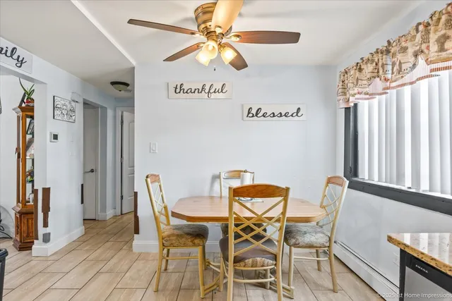 a dining room with furniture and a chandelier fan
