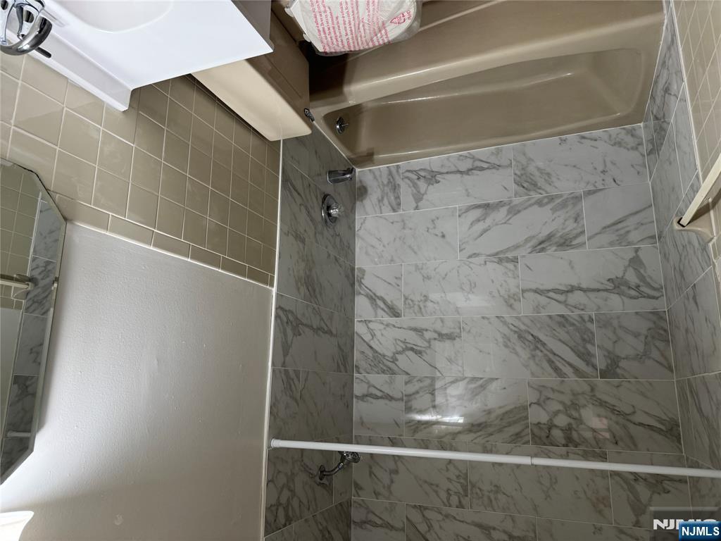 107 Bellgrove Drive, Unit 3B Mahwah, NJ 07430 - Photo 7 of 11 a bathroom with a bathtub and a shower