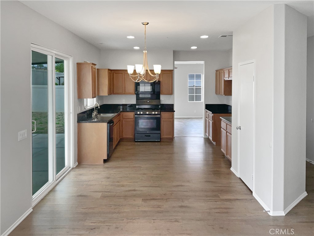 1966 Echo Road San Jacinto, CA 92582 - Photo 11 of 23 a kitchen with stainless steel appliances kitchen island granite countertop a stove top oven a sink and a refrigerator