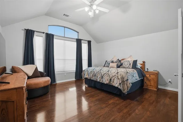 a bedroom with a bed couch and a large window