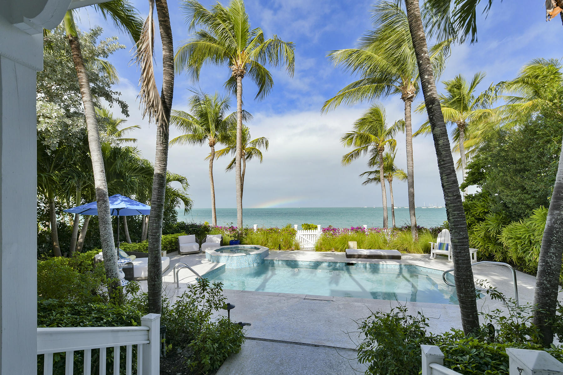 5 Sunset Key Drive Key West, FL 33040 - Photo 2 of 37 a view of a swimming pool with a garden and palm trees