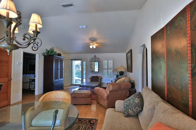 a bedroom with a bed a chandelier and dresser