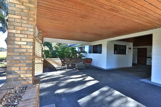 a view of swimming pool with lawn chairs and iron fence