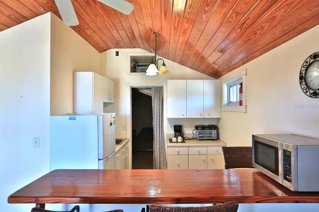 a view of swimming pool with sitting area and large trees