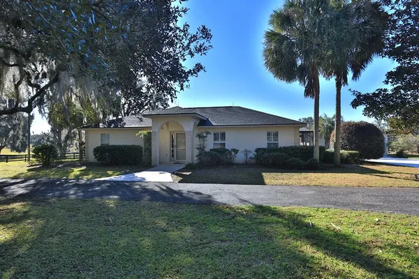 a living room with furniture a lamp wooden floor and a chandelier