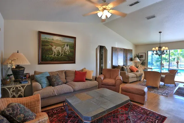 a living room with furniture chandelier and wooden floor