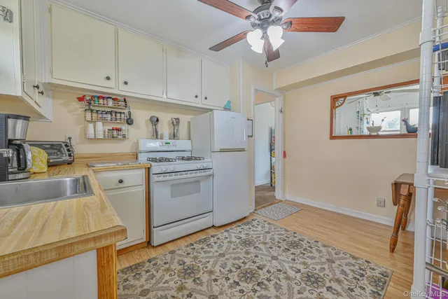 a kitchen with a refrigerator sink and white cabinets