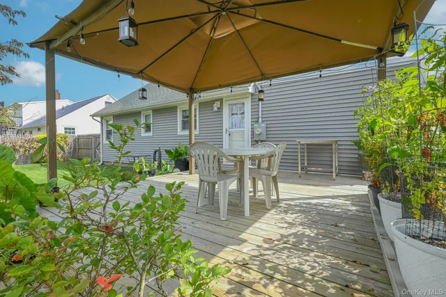a patio with table and chairs and potted plants