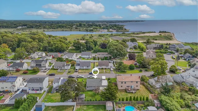 an aerial view of a city with lots of residential buildings ocean and mountain view in back