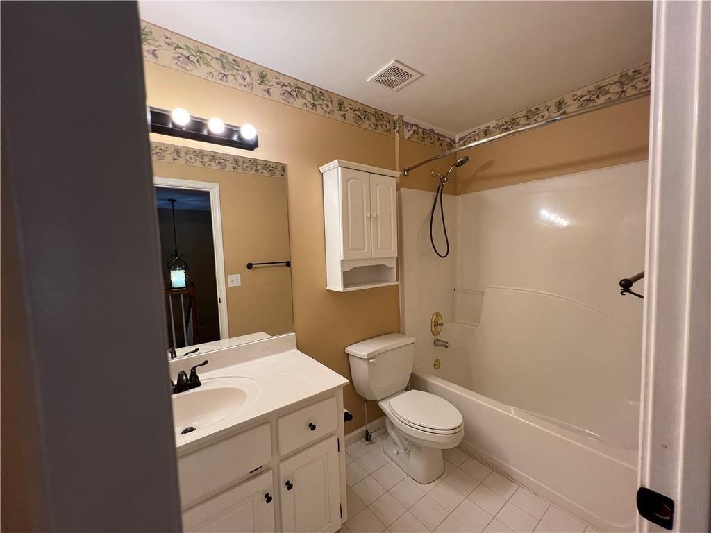 2550 Wellsley Lane Cumming, GA 30041 - Photo 13 of 22 a bathroom with a granite countertop toilet a sink and shower