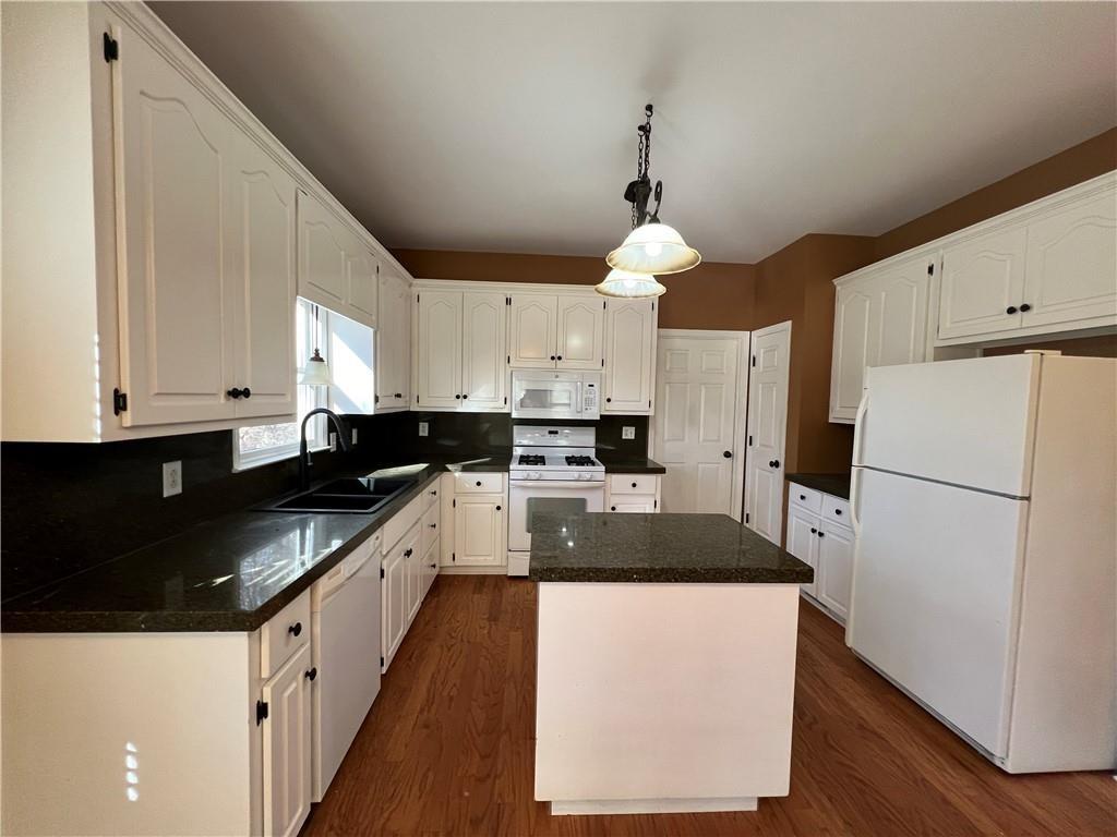 2550 Wellsley Lane Cumming, GA 30041 - Photo 8 of 22 a kitchen with granite countertop a refrigerator a sink dishwasher a stove and white cabinets with wooden floor