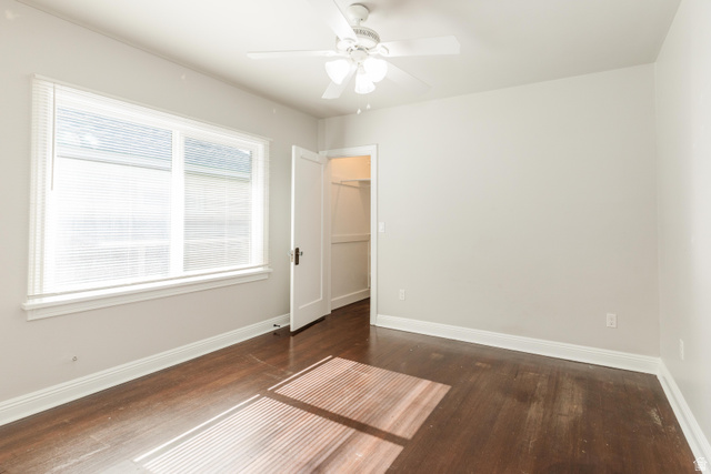 227 West 200 North Logan, UT 84321 - Photo 25 of 44 Bright room featuring a large window with white blinds, dark wood-finish flooring, a white ceiling fan, light-colored walls, and a white interior door