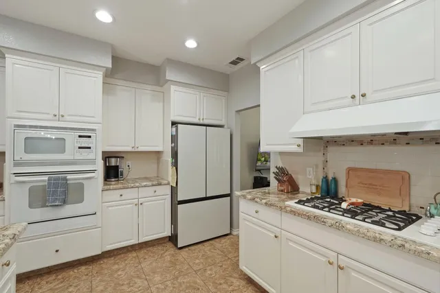 a kitchen with white cabinets and white appliances