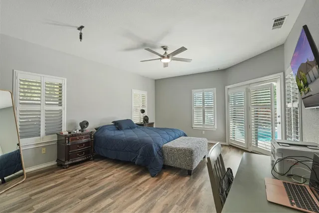 a bedroom with a large bed a chandelier and dresser