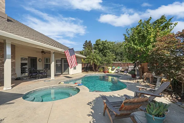 a view of a house with backyard sitting area and garden