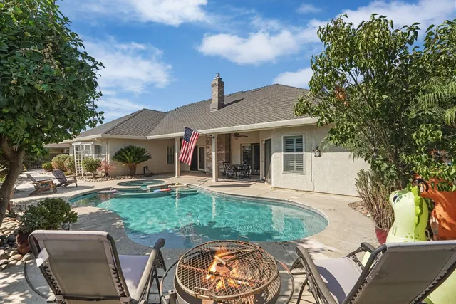 a view of a house with swimming pool and porch with furniture
