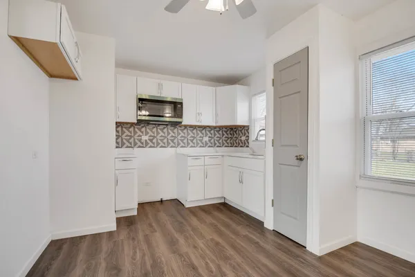 a kitchen with a refrigerator and a stove top oven