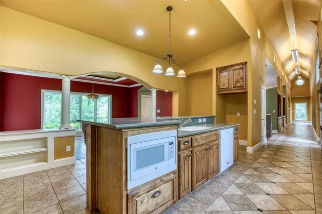 a kitchen with kitchen island granite countertop a stove and a sink