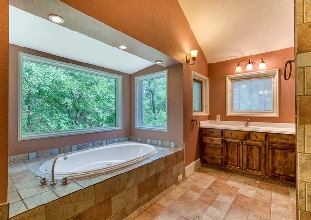 a bathroom with a tub sink and mirror