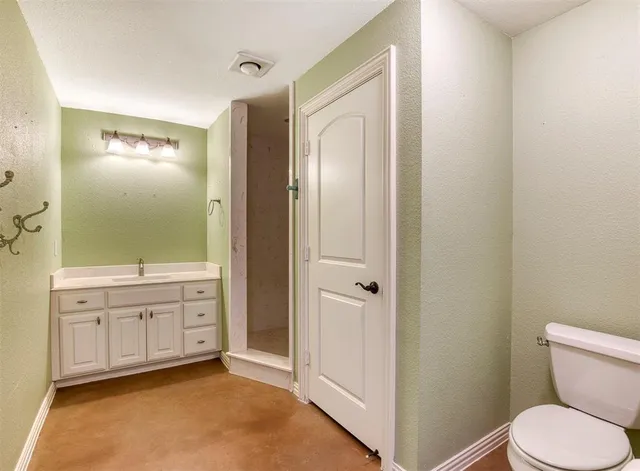 an empty room with a chandelier fan and windows