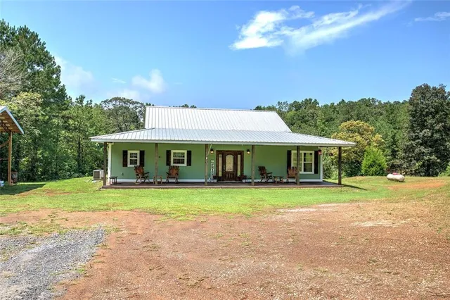a front view of a house with a yard and trees