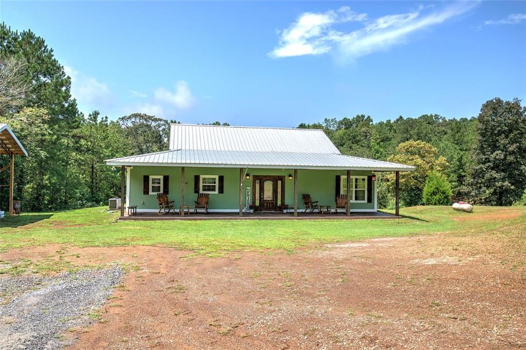 a front view of a house with a yard and trees