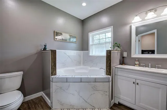 a living room with furniture a lamp and wooden floor