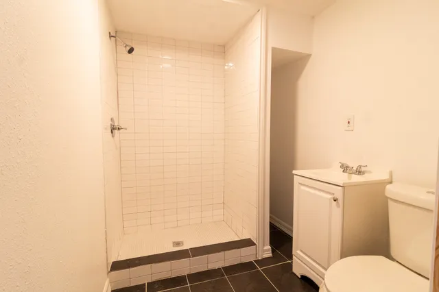 a bathroom with a granite countertop shower and a toilet