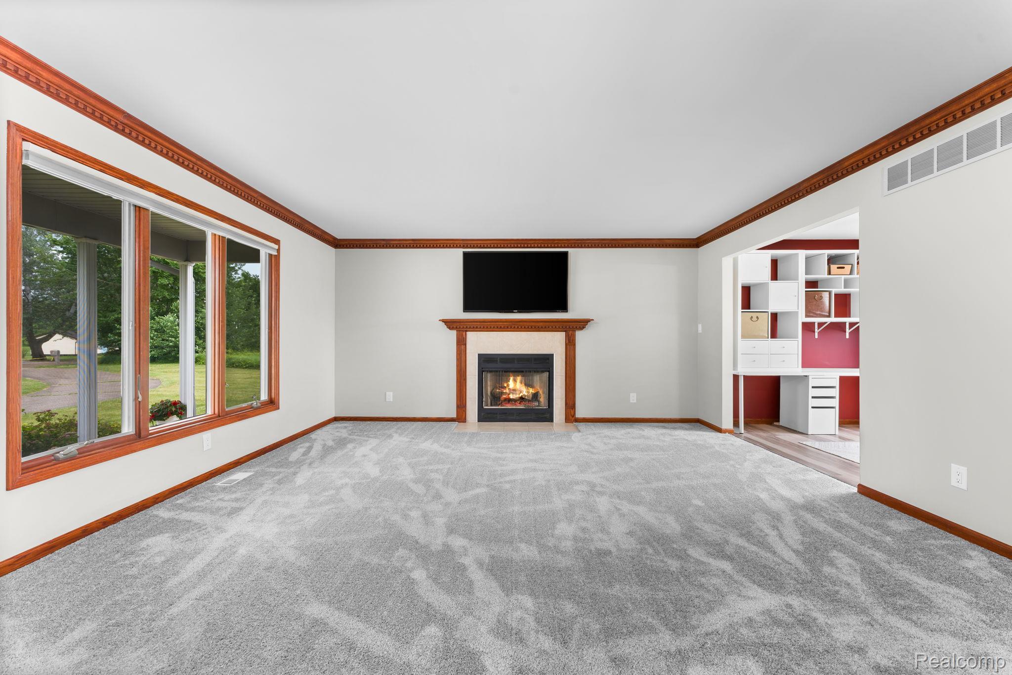 2381 Burke Road Fowlerville, MI 48836 - Photo 4 of 31 Spacious interior featuring a fireplace with a wood mantel, new carpeting