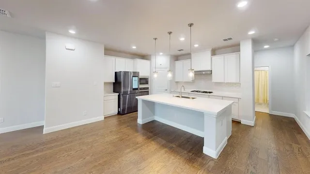 a kitchen with kitchen island a sink stainless steel appliances and cabinets