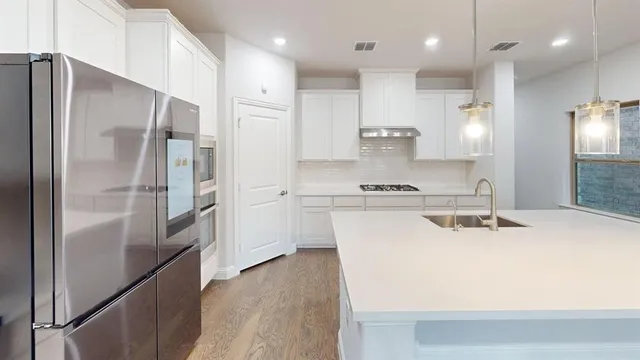a kitchen with kitchen island a refrigerator stove and sink