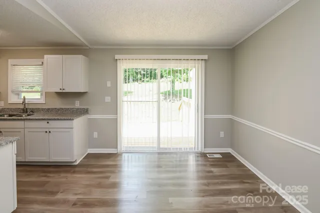 a kitchen with wooden floors and white cabinets