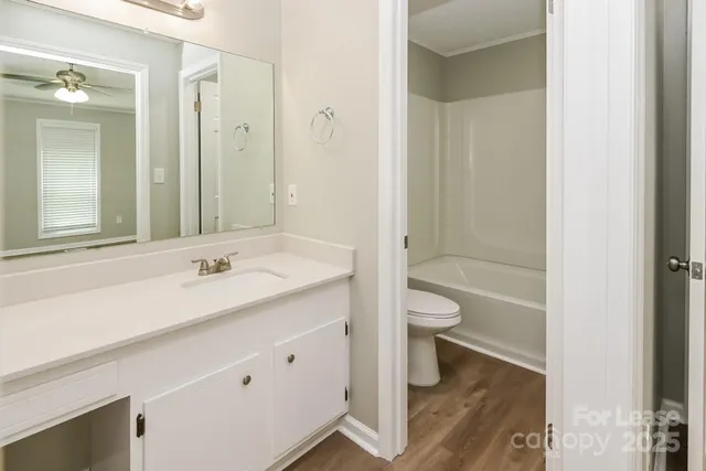 a bathroom with a granite countertop sink a toilet and a large mirror