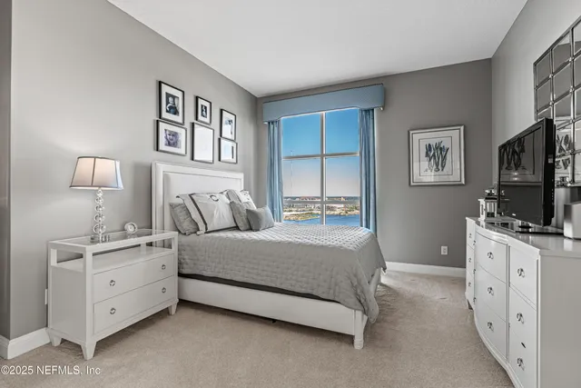 a spacious bedroom with a bed and a flat screen tv