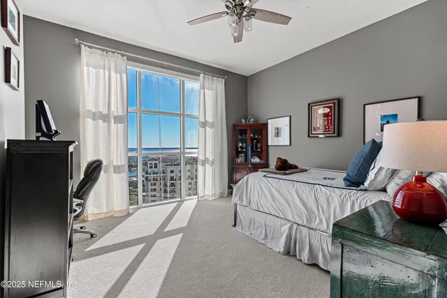 a bedroom with a bed a couch and a chandelier