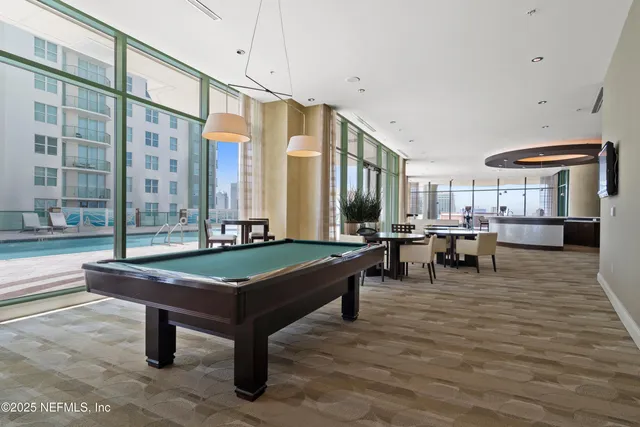 a room with pool table and windows