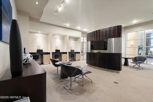 a living room with furniture a flat screen tv and kitchen view