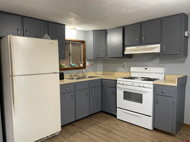 a kitchen with a refrigerator sink and cabinets