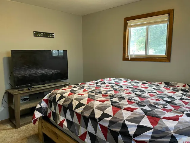 a bedroom with a bed and a flat screen tv