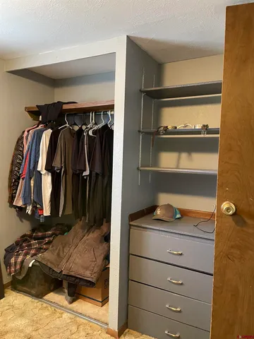 a view of walk in closet with clothes and shoes