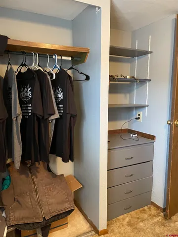 a view of walk in closet with clothes and shoes