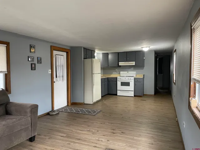a view of kitchen with stainless steel appliances granite countertop a refrigerator and a stove top oven