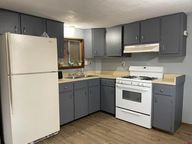 a kitchen with a refrigerator sink stove and cabinets