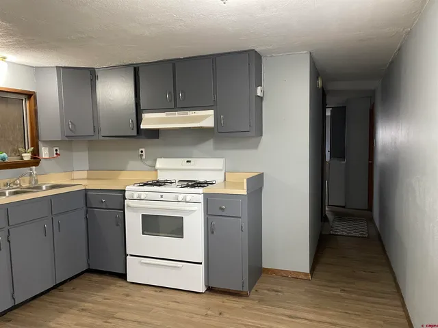 a kitchen with a stove cabinets and wooden floor