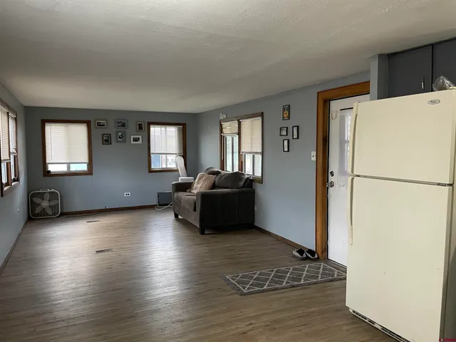 a living room with furniture and a refrigerator