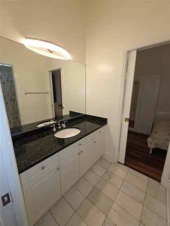 a bathroom with a granite countertop sink and a mirror
