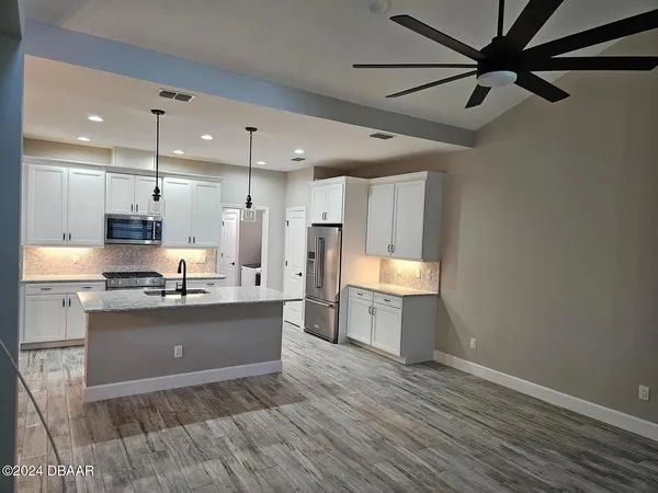 a kitchen with a sink cabinets stainless steel appliances and a counter top space